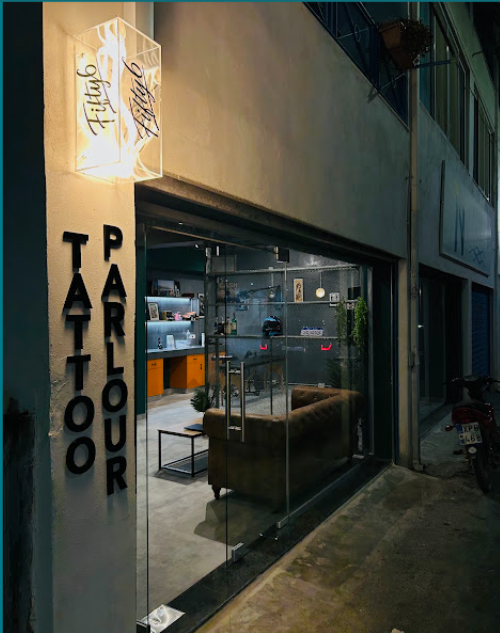 Fifty6 Tattoo Parlour storefront at night with illuminated sign