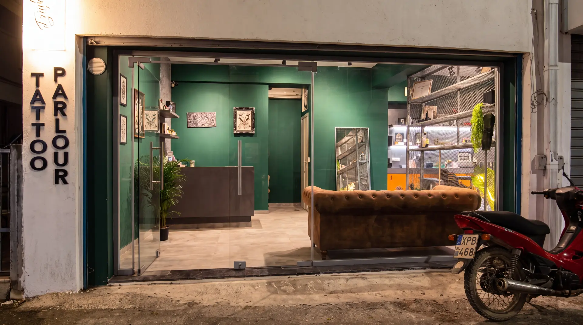 Fifty6 Tattoo Parlour interior with green walls, leather sofa and tattoo station