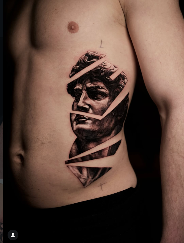 Black and grey realism statue tattoo on ribs