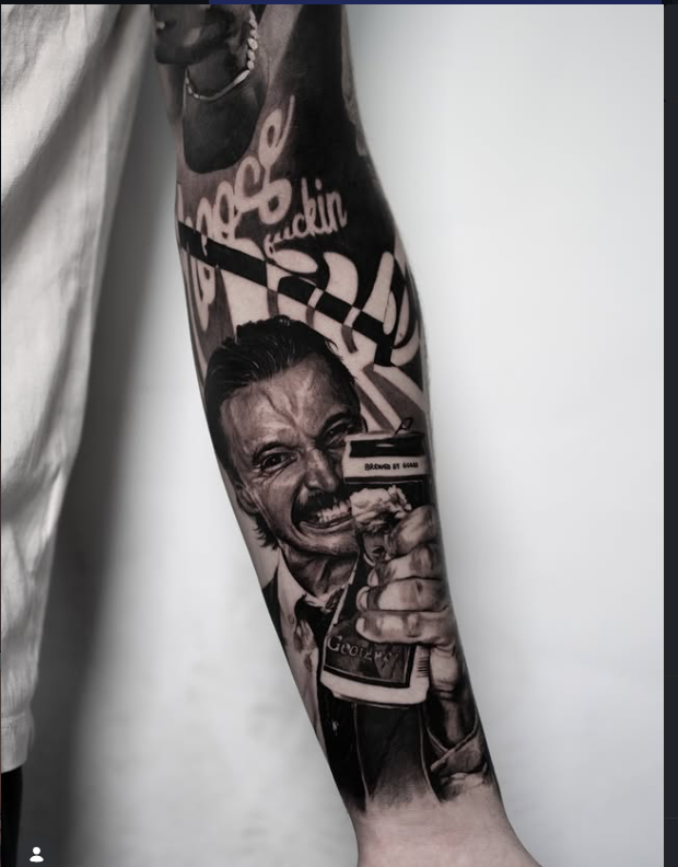 Black and grey portrait tattoo on forearm
